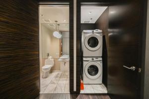 a bathroom with a washing machine and a toilet at Intimo Palms Place Penthouse in Las Vegas