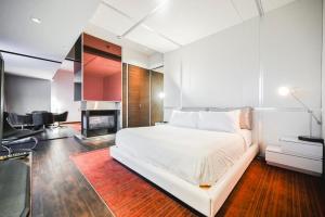 1 dormitorio con cama blanca y chimenea en Intimo Palms Place Penthouse en Las Vegas