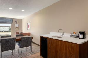 a kitchen with a sink and a counter with chairs at Hampton Inn St. Louis-Columbia in Millstadt Junction