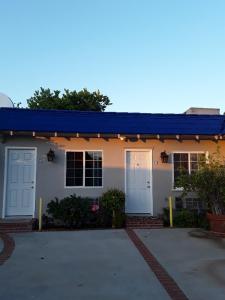 uma casa com um telhado azul e uma garagem em Rest Haven Motel em Los Angeles