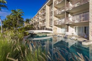 a hotel with a swimming pool in front of a building at Sonesta Ocean Point Resort- All Inclusive - Adults Only in Maho Reef