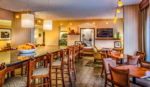 Hampton Inn Washington في واشنطن: مطعم به بار به طاولات وكراسي
