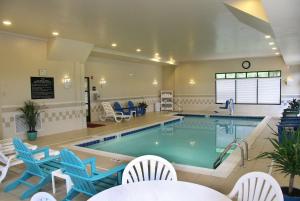 a large pool with blue chairs and a swimming pool at Hampton Inn Washington in Washington