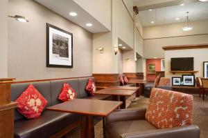 a waiting room with couches and tables and a tv at Hampton Inn & Suites Williamsburg-Central in Williamsburg