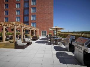 a patio with a grill and a table and a building at Homewood Suites by Hilton Halifax - Downtown in Halifax