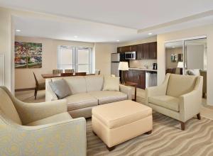 a living room with a couch and chairs and a kitchen at Homewood Suites by Hilton Halifax - Downtown in Halifax