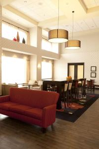 a living room with a red couch and a table at Hampton Inn & Suites by Hilton Lethbridge in Lethbridge