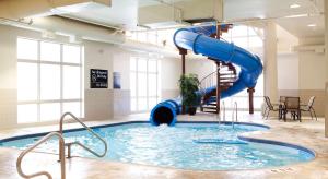 uma grande piscina com um escorrega azul em Hampton Inn & Suites by Hilton Lethbridge em Lethbridge