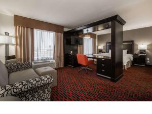 a hotel room with a bedroom with a bed and a desk at Hampton Inn & Suites by Hilton Lethbridge in Lethbridge