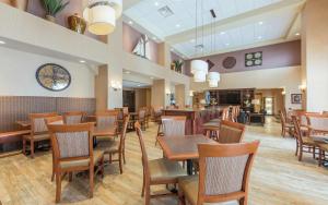 a restaurant with wooden tables and chairs and a clock at Hampton Inn & Suites by Hilton Moncton in Moncton