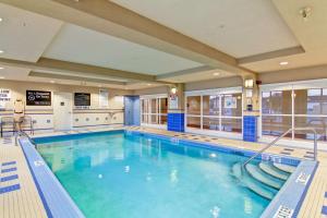 a large indoor swimming pool with blue water at Hampton Inn London Ontario in London