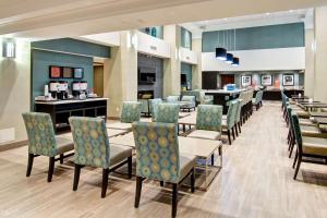 a dining room with chairs and tables and a bar at Hampton Inn London Ontario in London