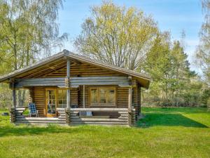 Cabaña de madera con porche en un campo en Holiday home Eskebjerg XI, en Eskebjerg