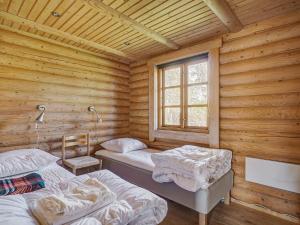 um quarto com 2 camas num chalé de madeira em Holiday home Eskebjerg XI em Eskebjerg