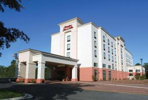 ein weißes Hotel mit einem rot-weißen Gebäude in der Unterkunft Hampton Inn & Suites Chesapeake-Battlefield Boulevard in Chesapeake