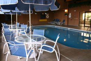 a pool with tables and chairs next to a swimming pool at Hampton Inn & Suites Chillicothe in Chillicothe