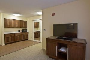 a large kitchen with wooden cabinets and a flat screen tv at Hampton Inn & Suites Chillicothe in Chillicothe