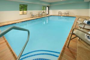 a large swimming pool with chairs in a hotel room at Hampton Inn Lake Charles in Lake Charles