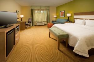 a hotel room with a bed and a flat screen tv at Hampton Inn Lake Charles in Lake Charles