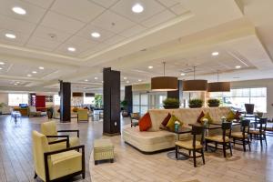 vestíbulo con sofá, mesas y sillas en Home2 Suites by Hilton Albuquerque Downtown/University, en Albuquerque