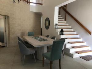 a dining room with a table and chairs and stairs at CASA DOS CATOS in Praia Verde