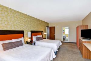 um quarto de hotel com duas camas e uma televisão de ecrã plano em Home2 Suites by Hilton Albuquerque Downtown/University em Albuquerque