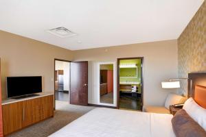 a hotel room with a bed and a flat screen tv at Home2 Suites by Hilton Albuquerque Downtown/University in Albuquerque