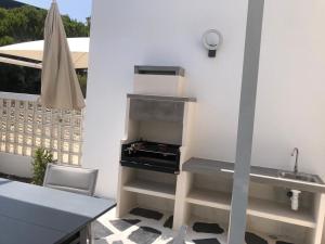 una cucina con griglia e tavolo di CASA DOS CATOS a Praia Verde