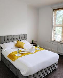 um quarto com uma grande cama branca e um cobertor amarelo em The Private Rooms in Paddington em Londres