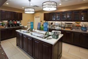 cocina grande con armarios de madera oscura y encimera en Homewood Suites Davenport, en Bettendorf