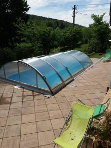 una piscina con una tienda y sillas en un patio en Borovnička en Borovnička