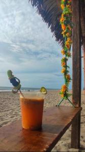 una bebida sentada en una mesa en la playa en Casa Playa Punta Bikini, en San Jacinto