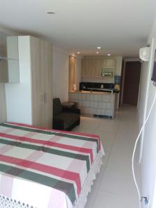 ein Hotelzimmer mit Bett und Wohnzimmer in der Unterkunft Flat de frente ao mar in Conde