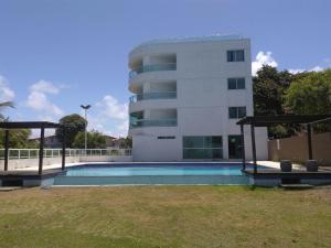 ein Gebäude mit einem Swimmingpool vor einem Gebäude in der Unterkunft Flat de frente ao mar in Conde + 10 Fotos
