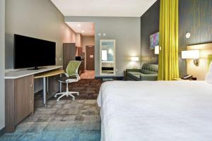 um quarto de hotel com uma cama e uma secretária com uma televisão em Home2 Suites By Hilton San Francisco Airport North em South San Francisco