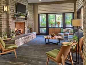 a lobby with a fireplace and chairs and a table at Hilton Garden Inn Gatlinburg in Gatlinburg