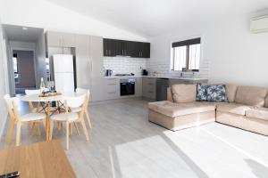 a living room and kitchen with a couch and a table at Meadowbank Lakehouse in Ellendale