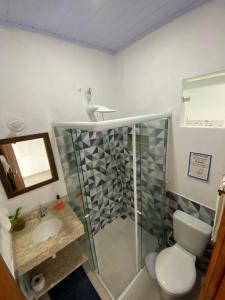 a bathroom with a shower and a toilet and a sink at Casa Caiçara in Praia de Araçatiba