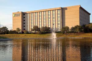 a large building with a lake in front of it at Embassy Suites by Hilton Chicago Schaumburg Woodfield in Schaumburg