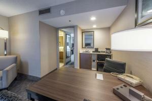 a conference room with a table and a kitchen at Embassy Suites by Hilton Chicago Schaumburg Woodfield in Schaumburg