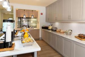 a kitchen with white cabinets and a white counter top at Hilton Garden Inn Saint Augustine Beach in Saint Augustine Beach