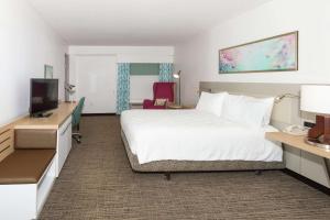 a hotel room with a bed and a tv at Hilton Garden Inn Saint Augustine Beach in Saint Augustine Beach