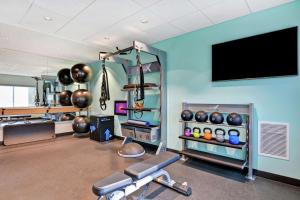 einen Fitnessraum mit Trainingsgeräten und einem Flachbild-TV in der Unterkunft Tru By Hilton Middletown in Middletown