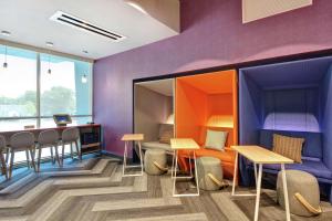米德爾敦的住宿－Tru By Hilton Middletown，一间拥有紫色墙壁和桌椅的房间