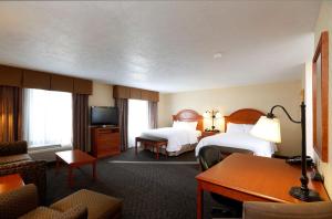 a hotel room with two beds and a desk at Hampton Inn Waterloo in Waterloo
