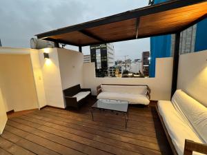 Un balcón con una cama y una mesa en un edificio en CUADRUPLEX Con TERRAZA, en Lima