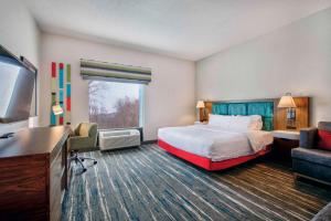 a hotel room with a bed and a desk at Hampton Inn Cortland in Cortland