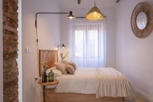 a bedroom with a bed with a mirror and a window at APARTAMENTO JUNTO A HOSPITAL REAL in Granada