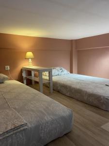 a bedroom with two beds and a table with a lamp at Modern House in Mytilene Center in Mytilini