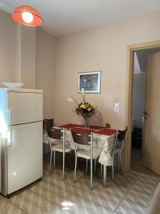 a dining room with a table with chairs and a refrigerator at Modern House in Mytilene Center in Mytilini